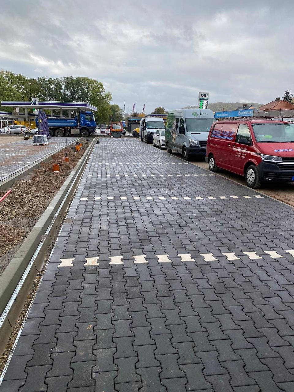 Fertiggestellter Parkplatz mit Betongroßplatten und Entwässerungsrinne
