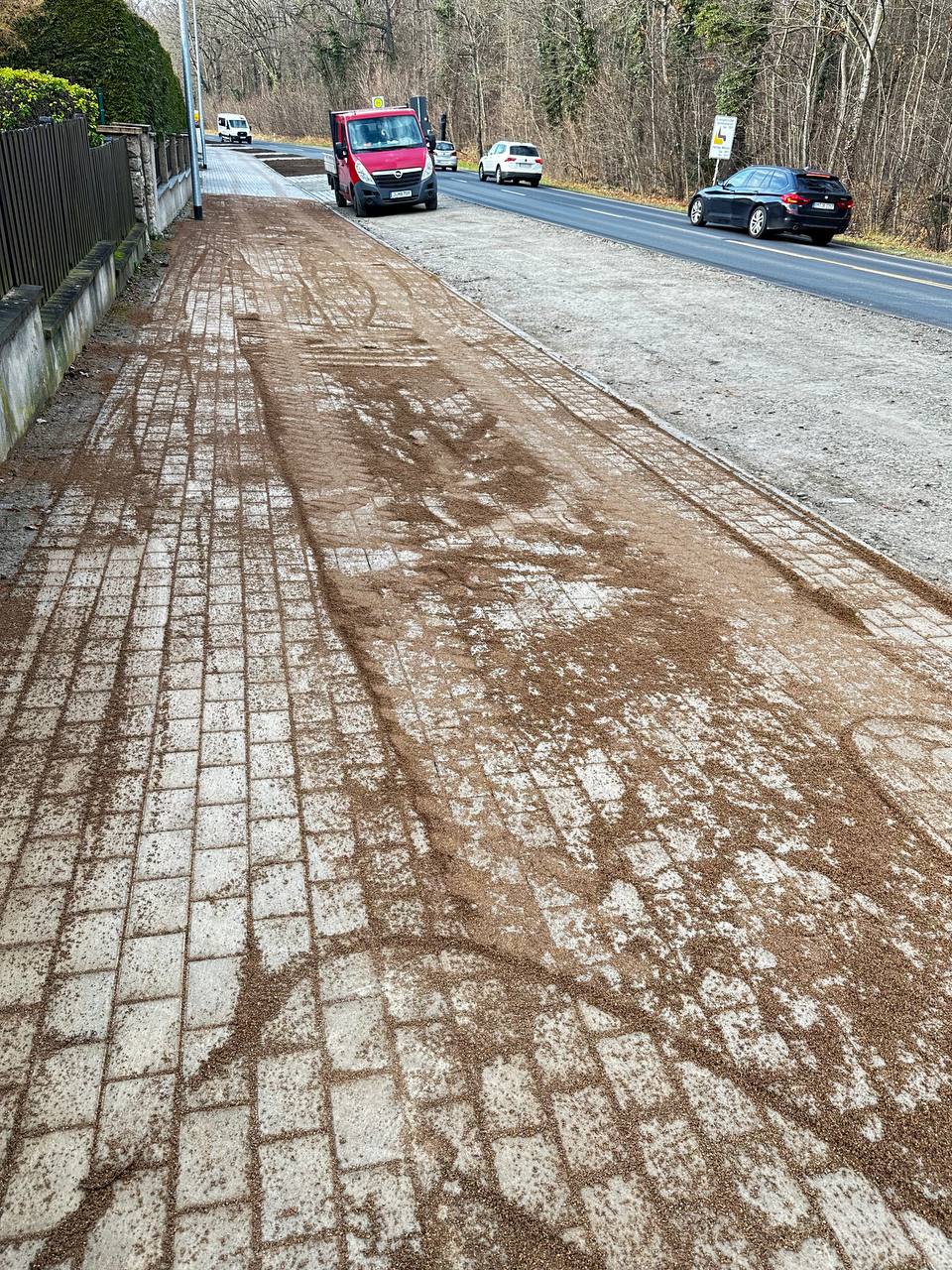 Kombination aus Pflasterbelag und frisch verlegtem Asphalt